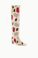 Side view tall suede patchwork boot in cream with red, brown, and yellow heart pattern