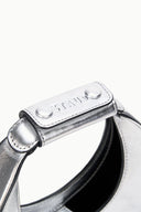 Silver top handle bar with snap button closure detail, black interior