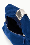 Cobalt suede cuff clutch with open zipper and dark interior lining