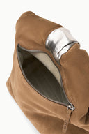 Husk brown cuff clutch shown side-on with front zipper and dark interior
