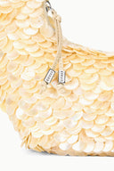 Cream sequined shoulder bag with scallop texture and side zipper, close-up.