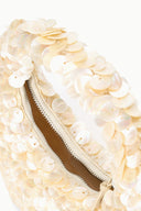 Cream sequined scallop bag with visible brown interior and zipper, close-up.