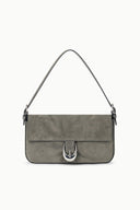 Gray suede shoulder bag with flap and curved metal front emblem