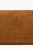Tan suede bag flap close-up with stitched edge and STAUD logo