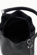 Black mini bucket bag interior view with drawstring and metal clasp at front