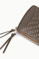Hand-woven wallet close-up with embossed MAE mark and metal zipper pull