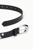 Black leather-look belt close-up with silver moon buckle and studded trim