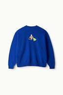 Blue knit sweater with crew neck and small beach-themed embroidered patch