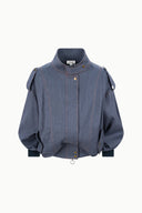 Dark blue chambray jacket flat lay with stand collar, snap buttons, and patch pockets