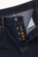 Indigo jeans waistband detail with button and coin pocket stitching