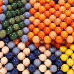 Close-up of multicolor beadwork on TIMMY shoulder bag, striped arrangement of round beads.