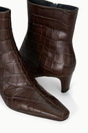 Pair of espresso-brown croc-texture ankle boots with mid-height slim heel