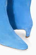 Blue suede ankle boot close-up with pointed toe and wooden-look heel