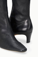 Black ankle sock boot showing side profile and low block heel.