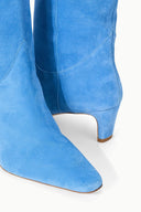 Light blue suede boot with low stacked heel and rounded back seam detail