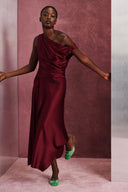 One-shoulder silk midi dress in deep burgundy with draped neckline and asym hem