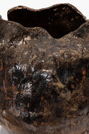 Textured ceramic vase close-up, dark speckled glaze with glossy highlights and open rim