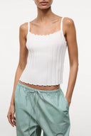 Ivory sleeveless tank top with ruffled neckline and scalloped hem