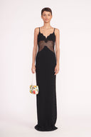Beaded bean bag purse with fruit motif top handle, carried by model in dark dress