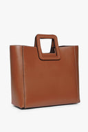 Tan leather bag with structured shape and top handle, side view